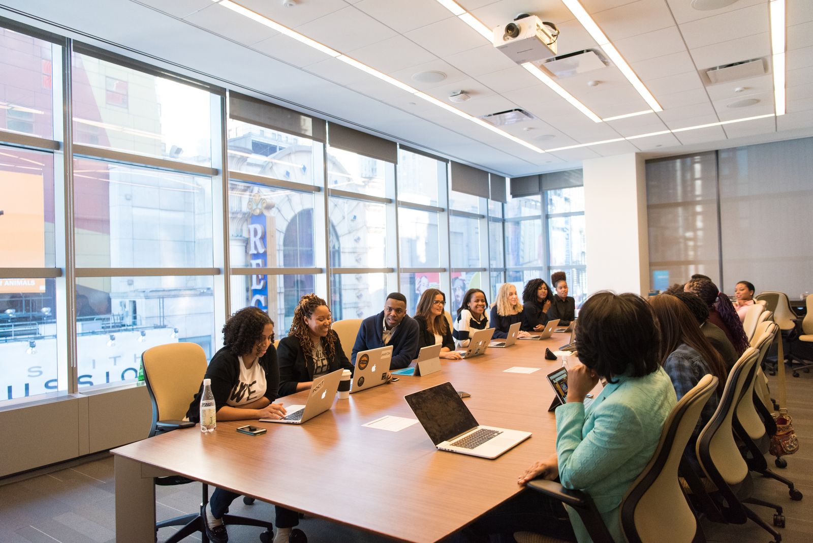 Sala de reunião com equipe trabalhando em laptops