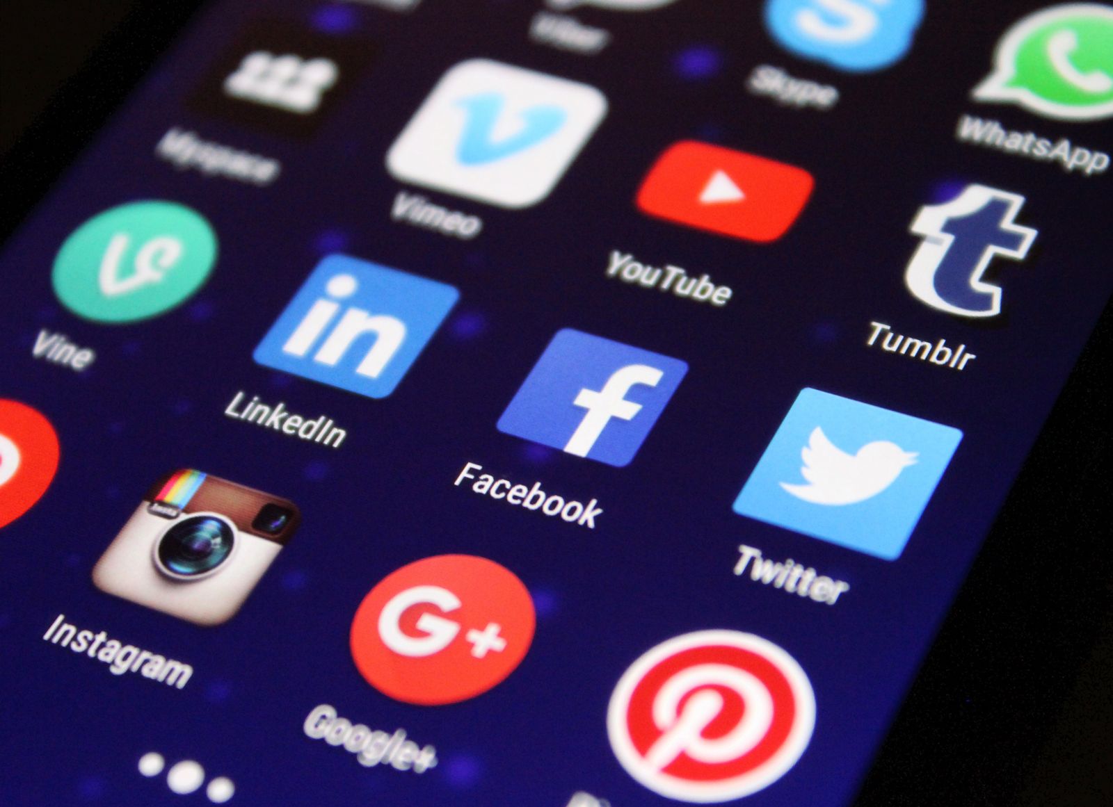 Pessoa segurando um celular com aplicativos de redes sociais na tela